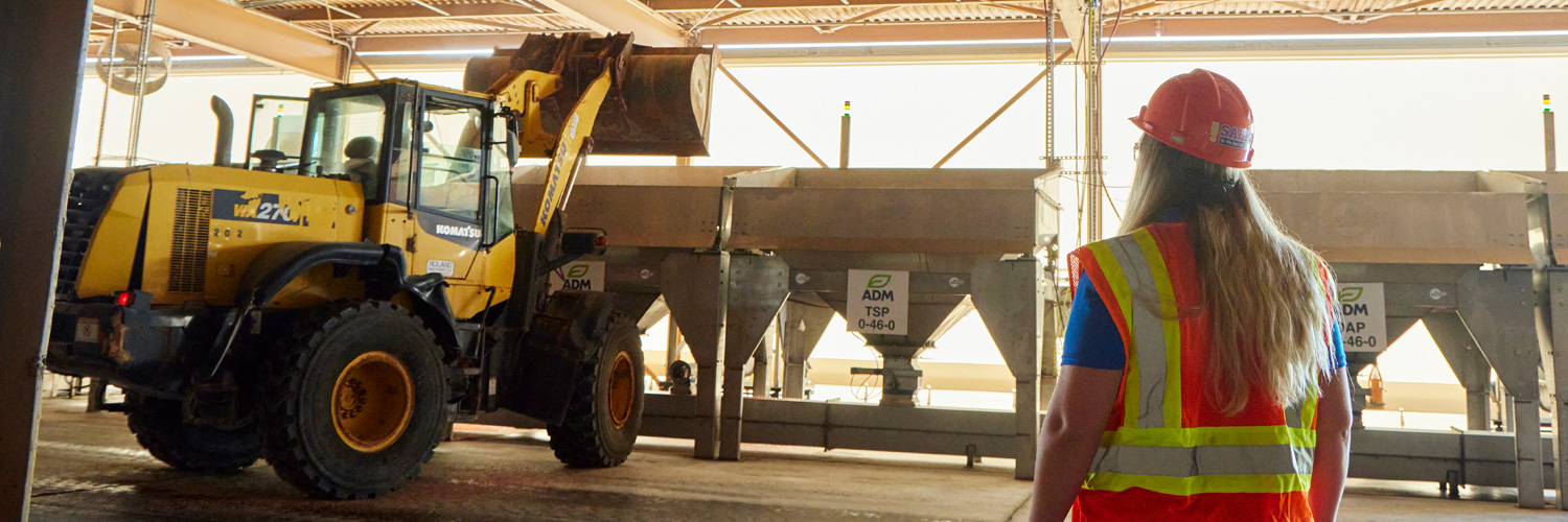 woman looking at some large farm machinery