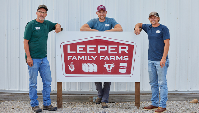 three men posing with a sign that says 
