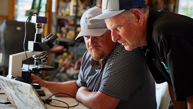 two producers looking at a computer screen